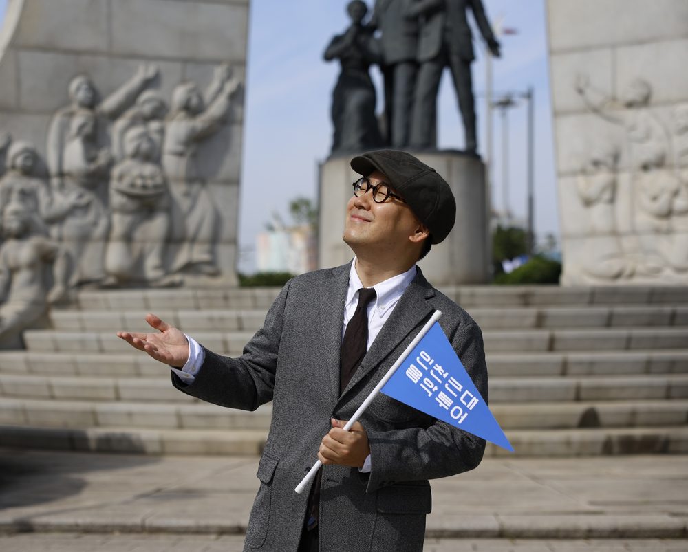 도슨트가 개항장에서 안내 깃발을 들고 해설하는 모습